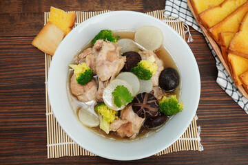 chicken and vegetable soup in white cup food on wooden table