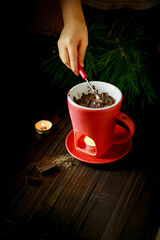 Cozy fondue mug with chocolate and burning candle, winter atmosphere