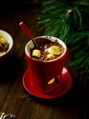 Cozy fondue mug with chocolate and burning candle, winter atmosphere