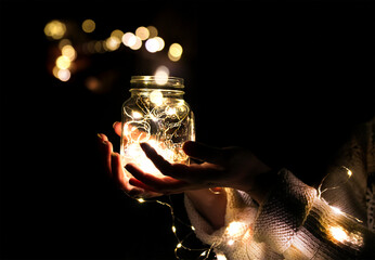Hands holding a jar with a garland and a bokeh - Powered by Adobe