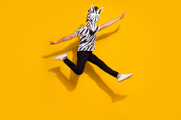 Photo of funny funky guy dressed wild animal costume jumping high arms sides isolated yellow color...