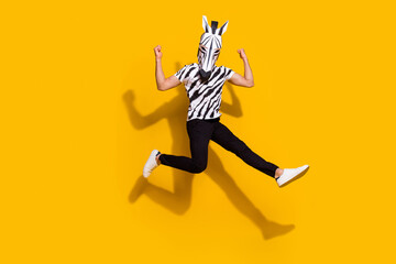Fototapeta na wymiar Full length photo of freak bizarre guy in zebra mask jump up show muscular body isolated over bright yellow color background