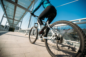 Fototapeta premium Woman riding bike at city on sunny day