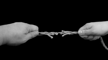 Hand of man and woman tug the rope, relationship conflict concept.