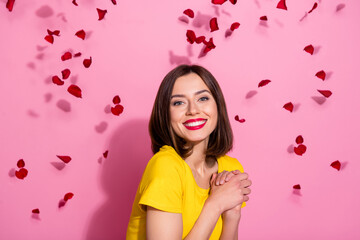 Portrait of attractive cute sweet cheerful girl having fun throwing small hearts isolated over pink pastel color background