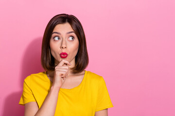 Photo of adorable thoughtful young woman wear yellow outfit arm chin sending kiss looking empty space smiling isolated pink color background