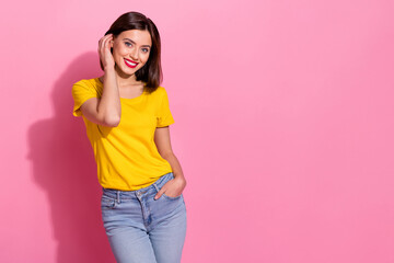 Photo of adorable cute young lady dressed yellow clothes smiling arm checking hairdo empty space isolated pink color background