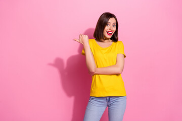 Portrait of attractive funky cheerful girl demonstrating copy space isolated over pink pastel color background