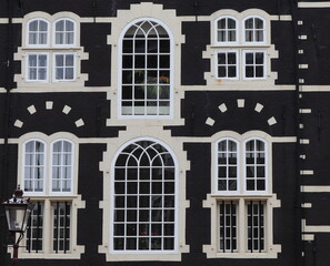 Amsterdam Oudezijds Voorburgwal Canal Historic Black and White House Facade Detail with Arched Windows, Netherlands