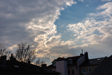 Dramatic clouds and blue sky over the roofs