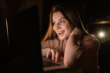 Euphoric and surprised woman winning online, watching a laptop a