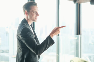 business caucasian man standing in office room near window