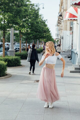 beautiful blonde woman dancing to music outside