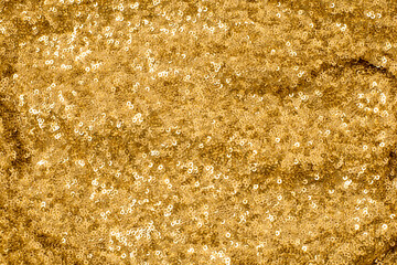 Shiny and glittering, golden fabric with sequins. Abstract background. Events, celebrations, Christmas, New Year. Trendy backdrop.