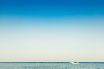 View to alone blue boat or ship yacht in silent sea or ocean water