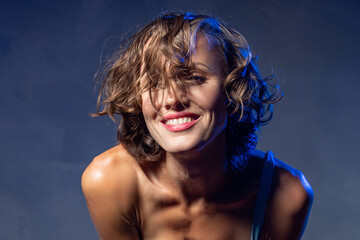 Naklejka premium Sexy young woman portrait. Seductive young woman with long hair posing in spotlight. Wide angle