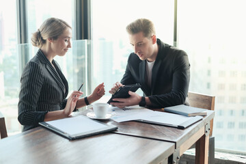 Two businessman and businesswoman couple meeting in co working space or office
