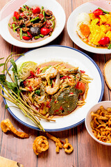 Green papaya salad (Som Tam) with fresh blue crab and shrimp, Cockle Salad, Corn and Salted Egg Salad (Chili, lime, tomato, fermented fish sauce as main ingredients) popular food in Isaan, Thailand.