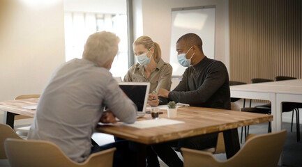 team working in an office wearing covid-19 pandemic masks