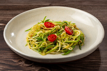 Zucchini spaghetti with tomatoes in garlic and oil.
