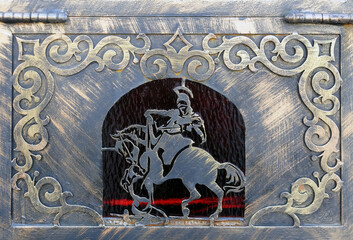 Metal panel with ornament and horse rider figure