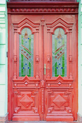 Fototapeta na wymiar Ornate red wooden door of old building in Kyiv Ukraine