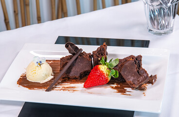 Postre de chocolate con helado y fresa.