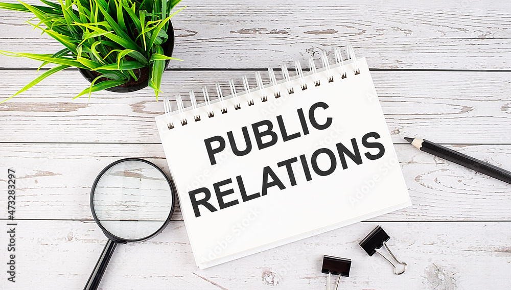 Aufkleber public relations text concept write on notebook with office tools on wooden background
