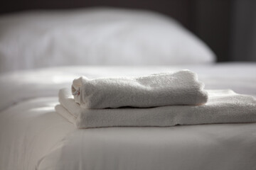 White clean towels stacked on the hotel bed. High quality photo