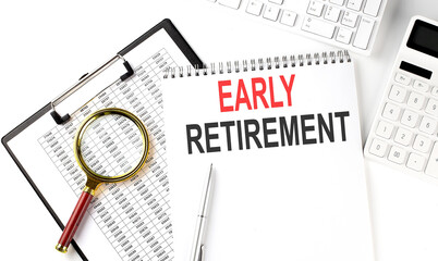 Office desk table with keyboard, notepad ,chart and calculator. Top view with text EARLY RETIREMENT
