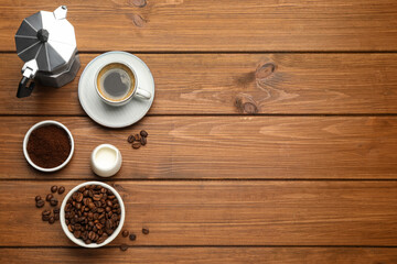 Flat lay composition with coffee grounds and roasted beans on wooden table, space for text