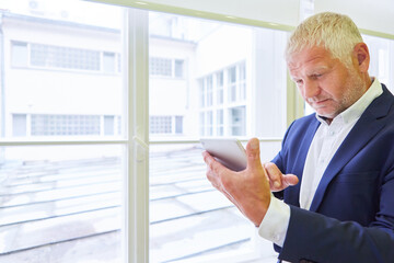 Fototapeta premium Business Mann mit Tablet PC nutzt eine App
