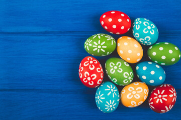 Colorful easter eggs on blue color wood background with space.