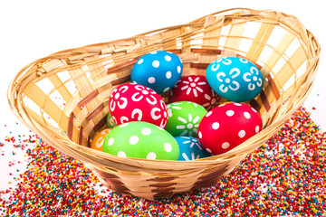 Basket with easter eggs on the background of colored beads