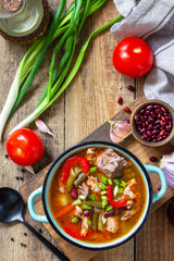 Traditional English thick soup with beef, beans and vegetables on a wooden table. Hot dinner or lunch. Top view flat lay.