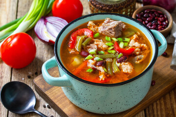 Traditional English thick soup with beef, beans and vegetables on a wooden table. Hot dinner or lunch.