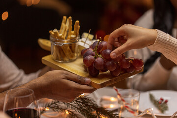 holidays, eating and celebration concept - close up of friends having christmas dinner at home and sharing food