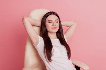 Obraz na płótnie Canvas Vertical portrait of pretty young happy smiling lady sitting on a chair rest relax sleep isolated over pink color background