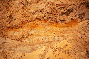 Textural sand, with  relief surface, multi-colored layers and different in size of granules, in outdoor sand career, after mining ore and sand for construction.