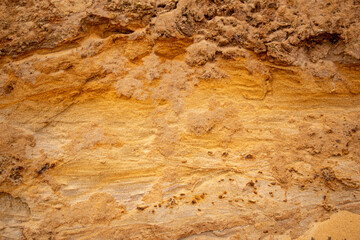 Textural sand, with  relief surface, multi-colored layers and different in size of granules, in outdoor sand career, after mining ore and sand for construction.