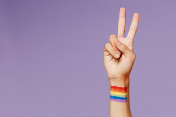 Cropped close up photo shot of gay man male hand arm showing victory v-sign friendly gesture...