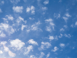 A lot of white fluffy clouds illuminated by the sun in the azure-blue sky view from below. Amazing sky background