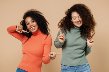 Two vivid excited young curly black women friends 20s wearing casual shirts clothes dance fooling...