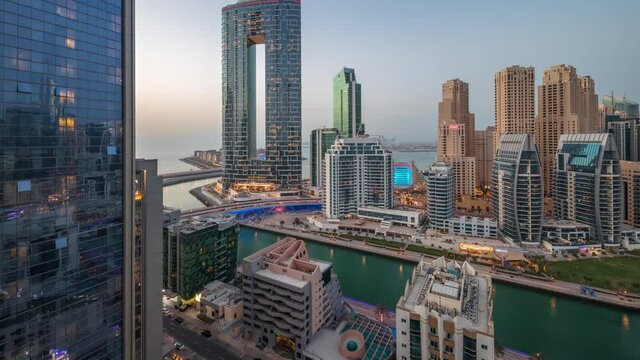 Dubai Marina skyscrapers and JBR district with luxury buildings and resorts aerial day to night timelapse
