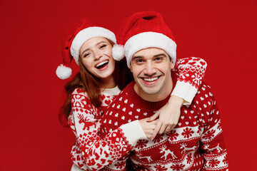 Young smiling cheerful couple friends two man woman 20s in sweater hat hug cuddle look camera...