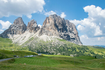 Fototapeta na wymiar Dolomites, italy, august 2018, green valley next to the Sassolungo mountains in Val Gardena