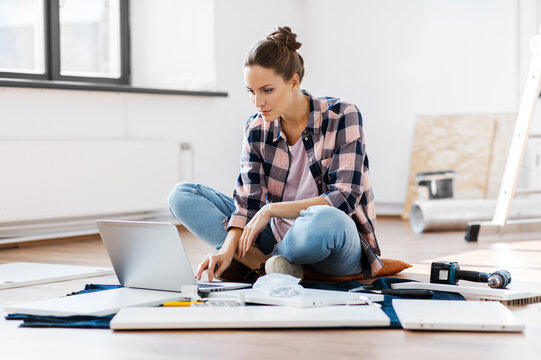 repair, improvement and furniture concept - woman with laptop assembling new locker at home