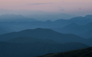 Mountain silhouette layers in the sunset light. Beautiful photography of the nature, blue layered background. Natural gradient.
