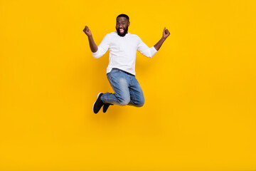 Fototapeta na wymiar Full body portrait of delighted guy raise fists celebrate success achievement isolated on yellow color background