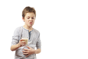 disgruntled child with a glass of milk isolated on white background.